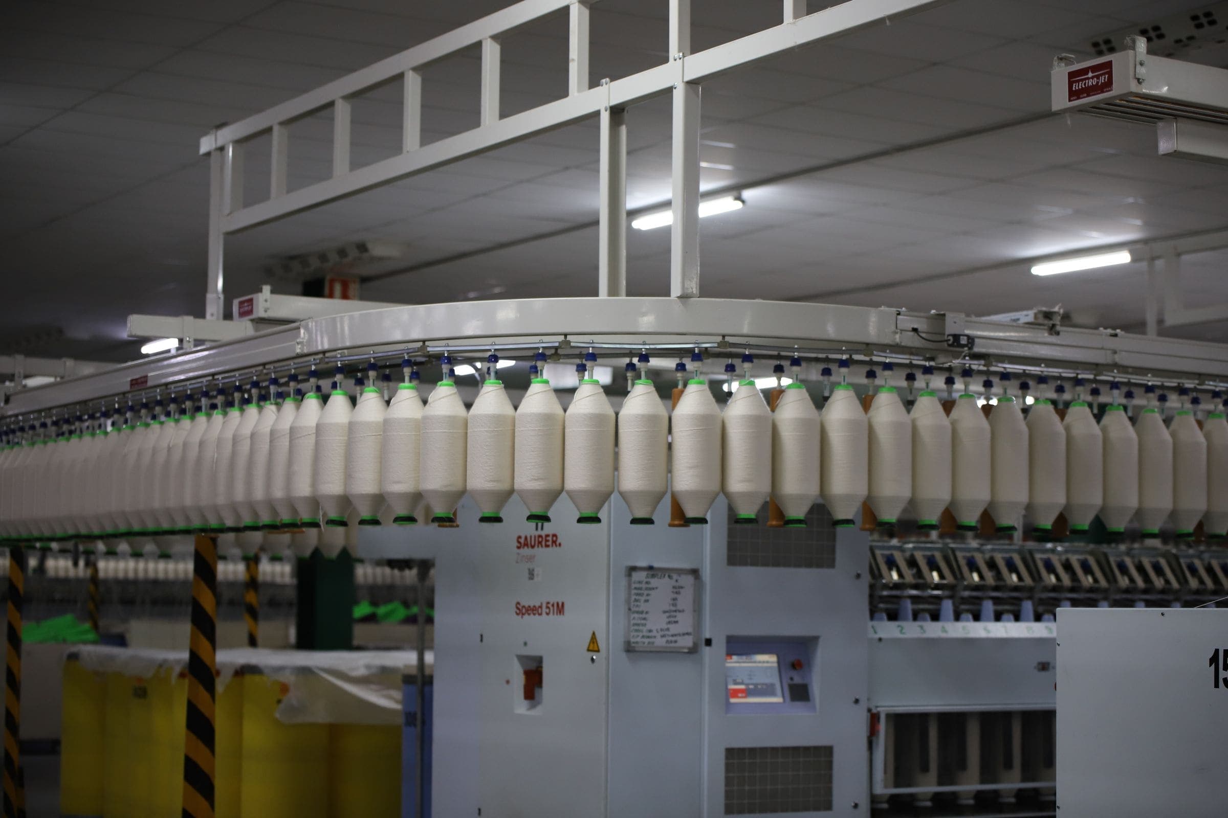 Spools of yarn moving along an automated textile production line